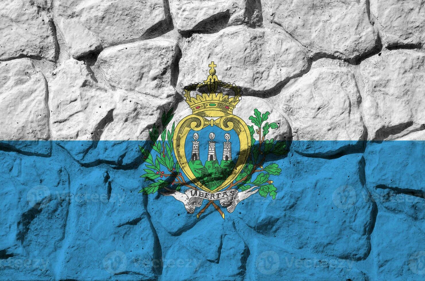 san marino bandeira retratado dentro pintura cores em velho pedra parede fechar-se. texturizado bandeira em Rocha parede fundo foto