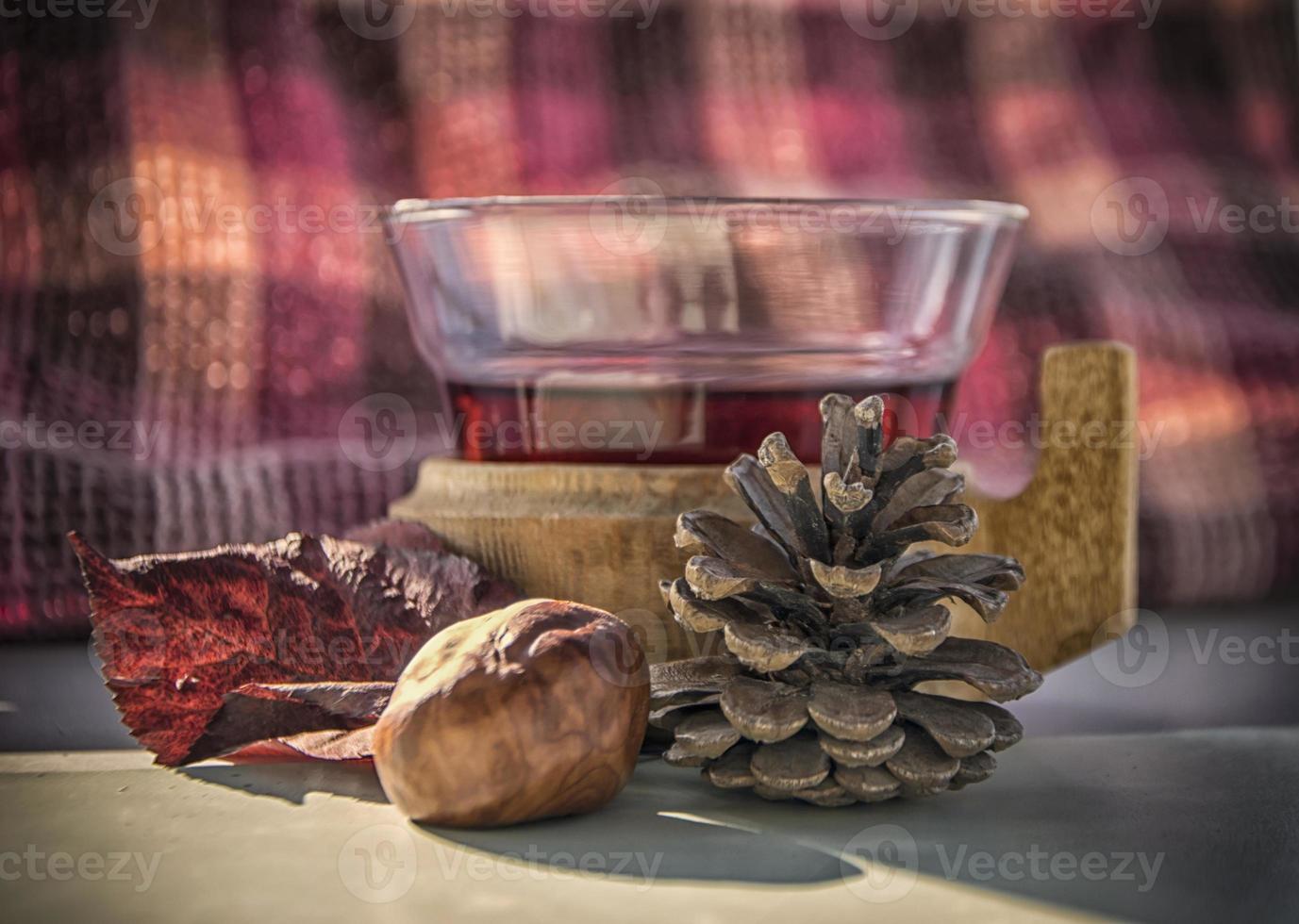 uma xícara de vinho quente em uma mesa com frutas de outono ao redor foto