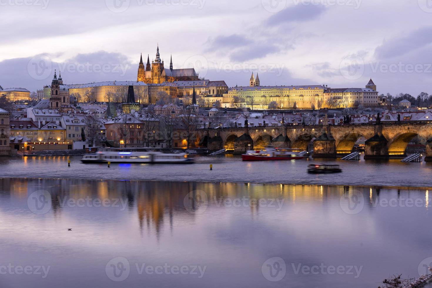 noite colorida com neve natal praga menor cidade com castelo gótico e ponte charles, república checa foto