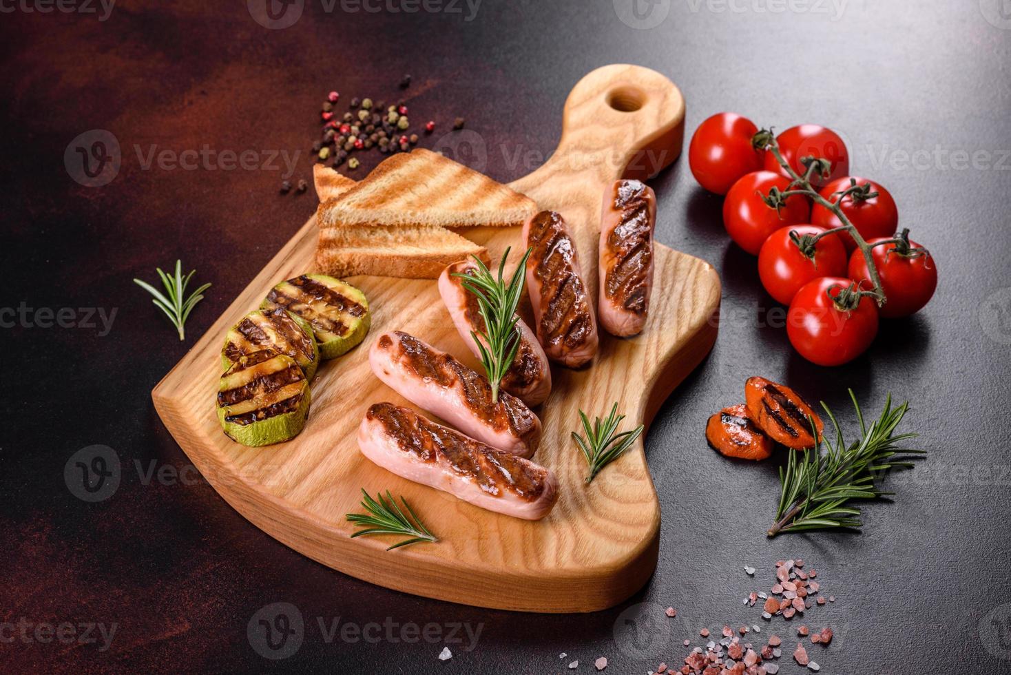 saborosas salsichas frescas grelhadas com vegetais, especiarias e ervas foto