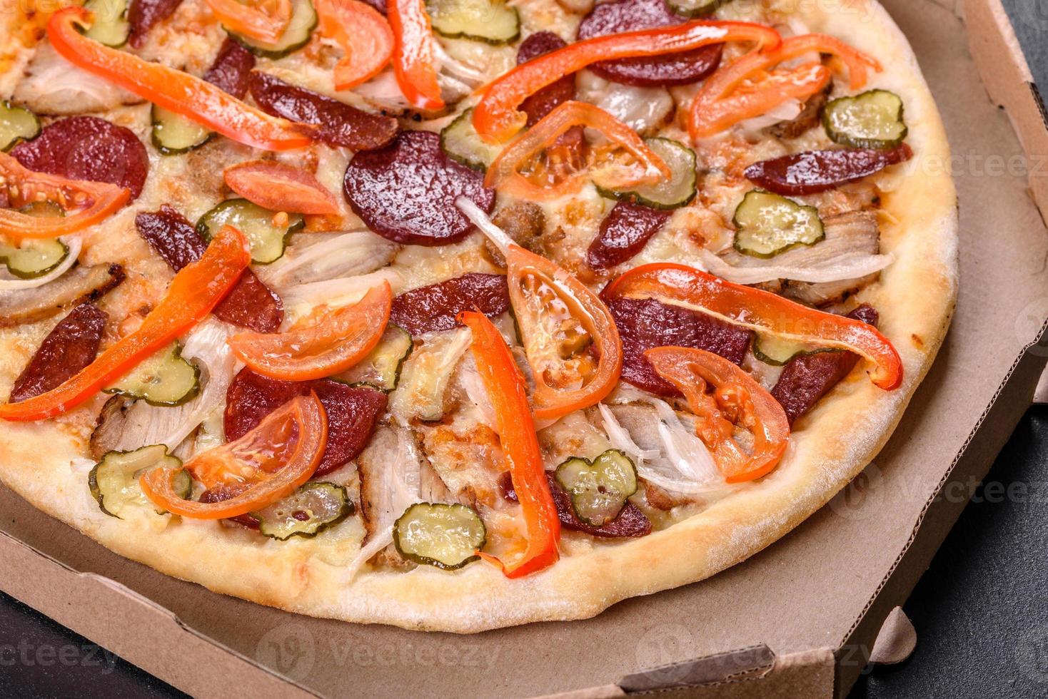 deliciosa pizza fresca feita em forno de lenha com linguiça, pimenta e tomate foto