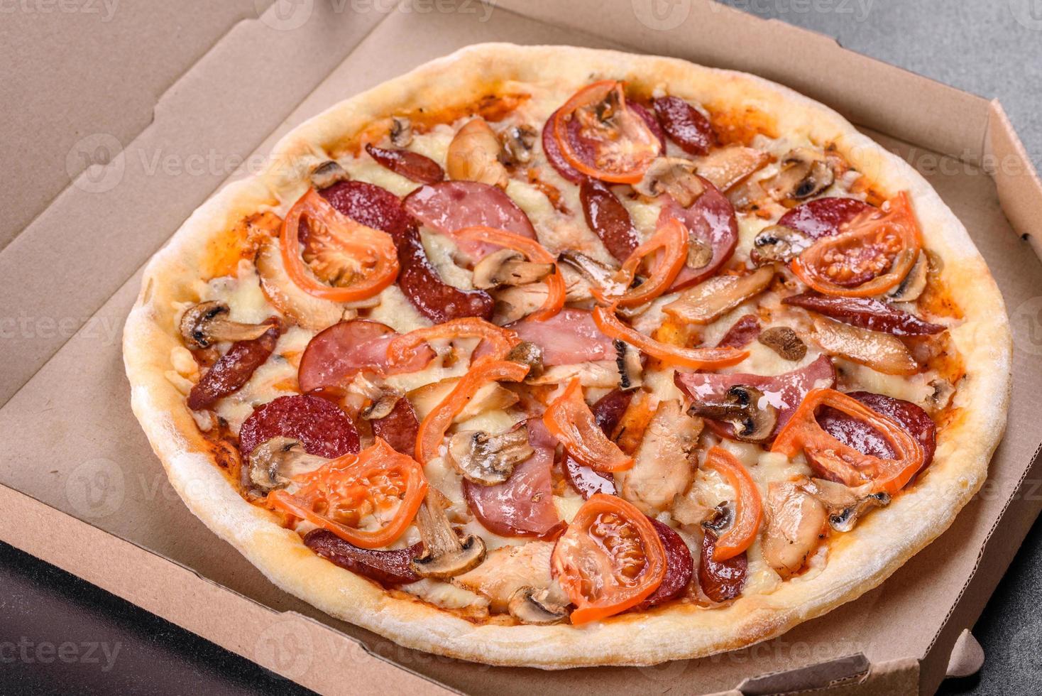 deliciosa pizza fresca feita em forno de lenha com linguiça, pimenta e tomate foto