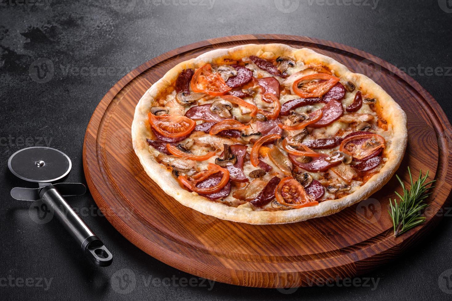 deliciosa pizza fresca feita em forno de lenha com linguiça, pimenta e tomate foto