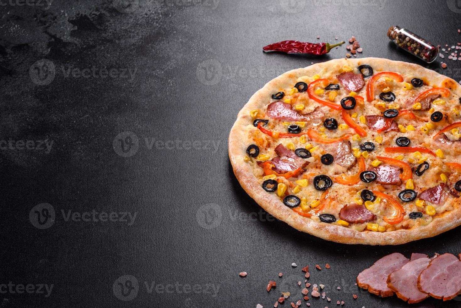 deliciosa pizza fresca feita em forno de lenha com azeitonas, pimenta e presunto foto