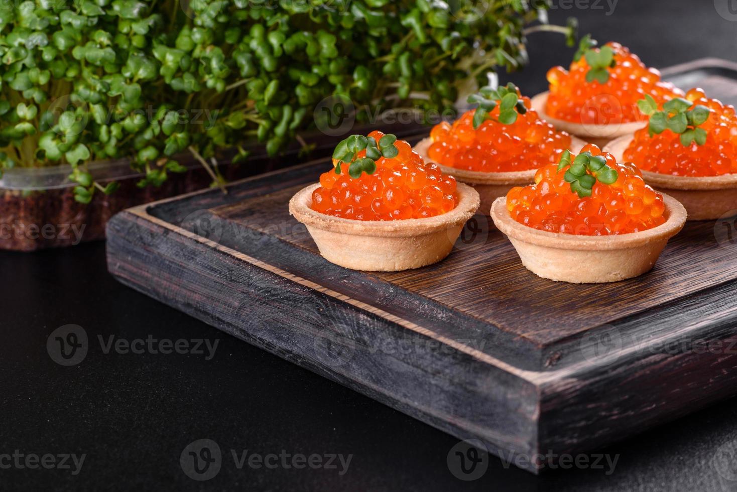 Caviar vermelho fresco delicioso em uma mesa de concreto escuro foto