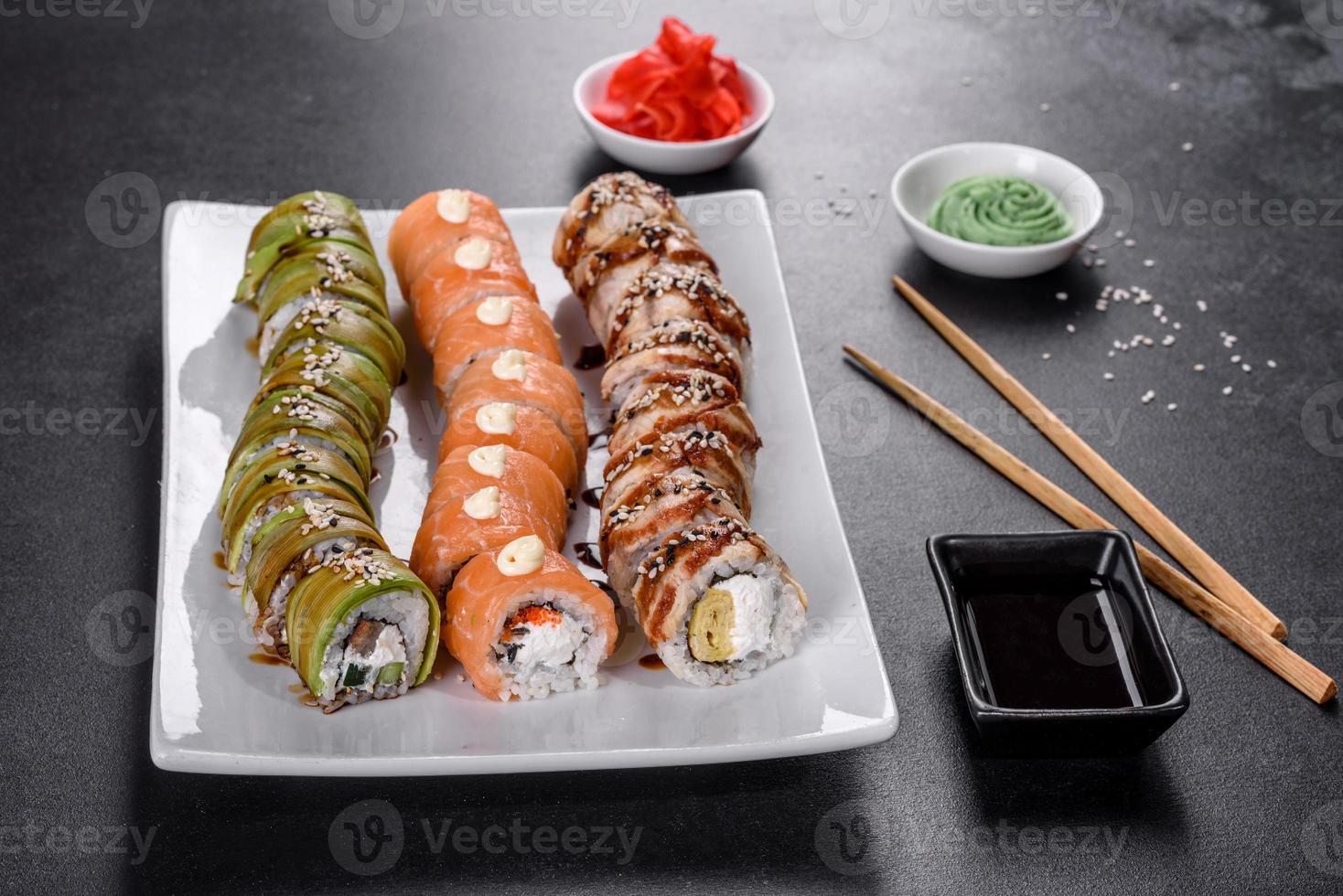 Saborosos rolos de sushi frescos dispostos na forma de um dragão com gengibre e wasabi foto