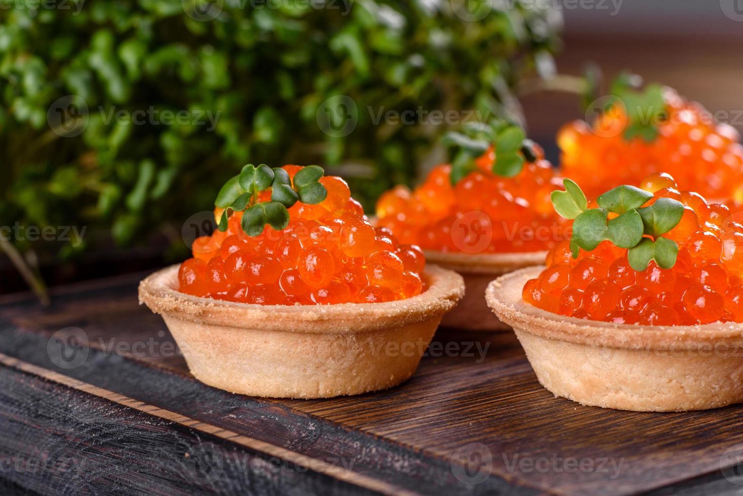 Caviar vermelho fresco delicioso em uma mesa de concreto escuro foto