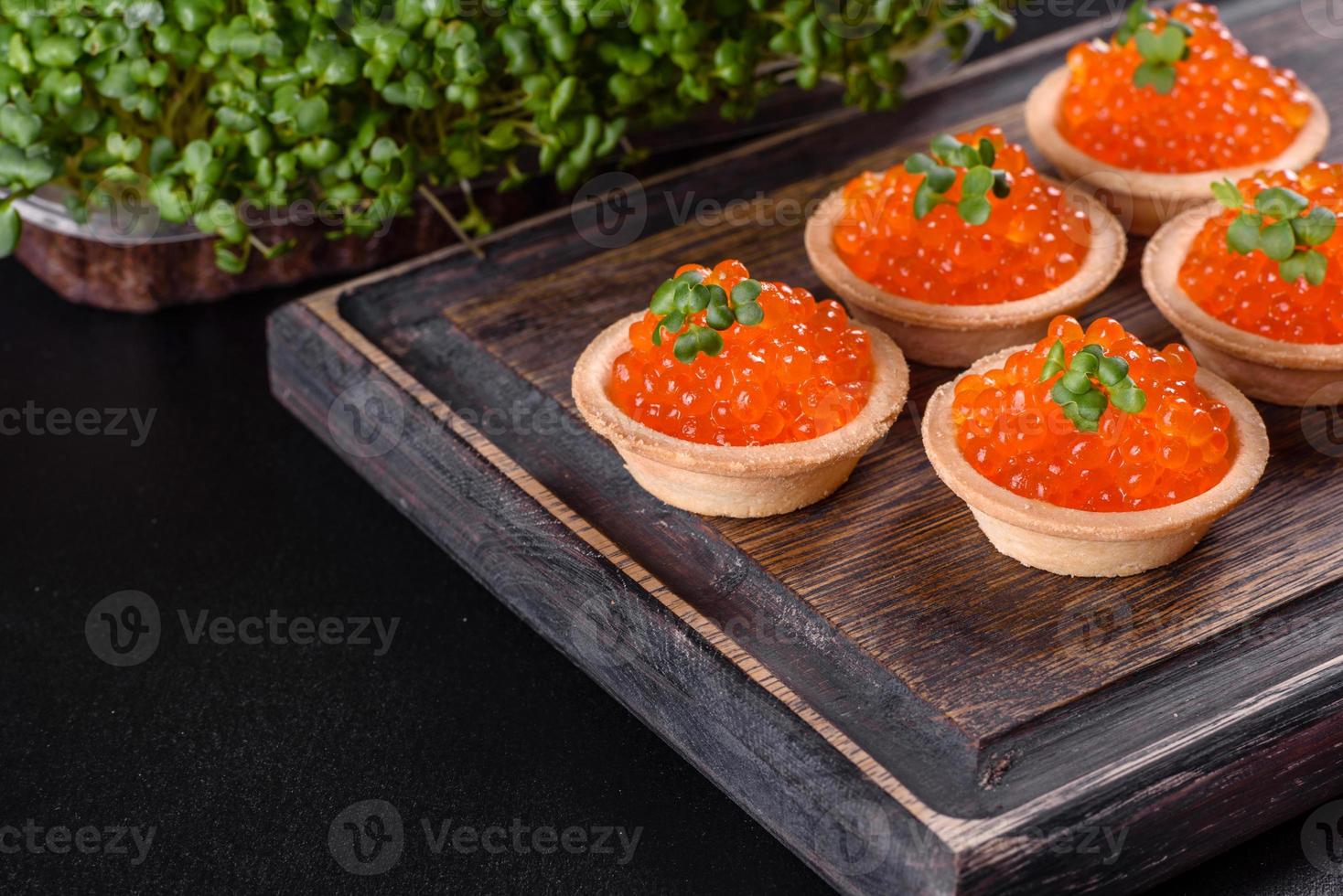 Caviar vermelho fresco delicioso em uma mesa de concreto escuro foto