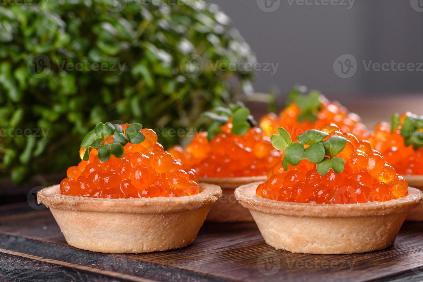 Caviar vermelho fresco delicioso em uma mesa de concreto escuro foto