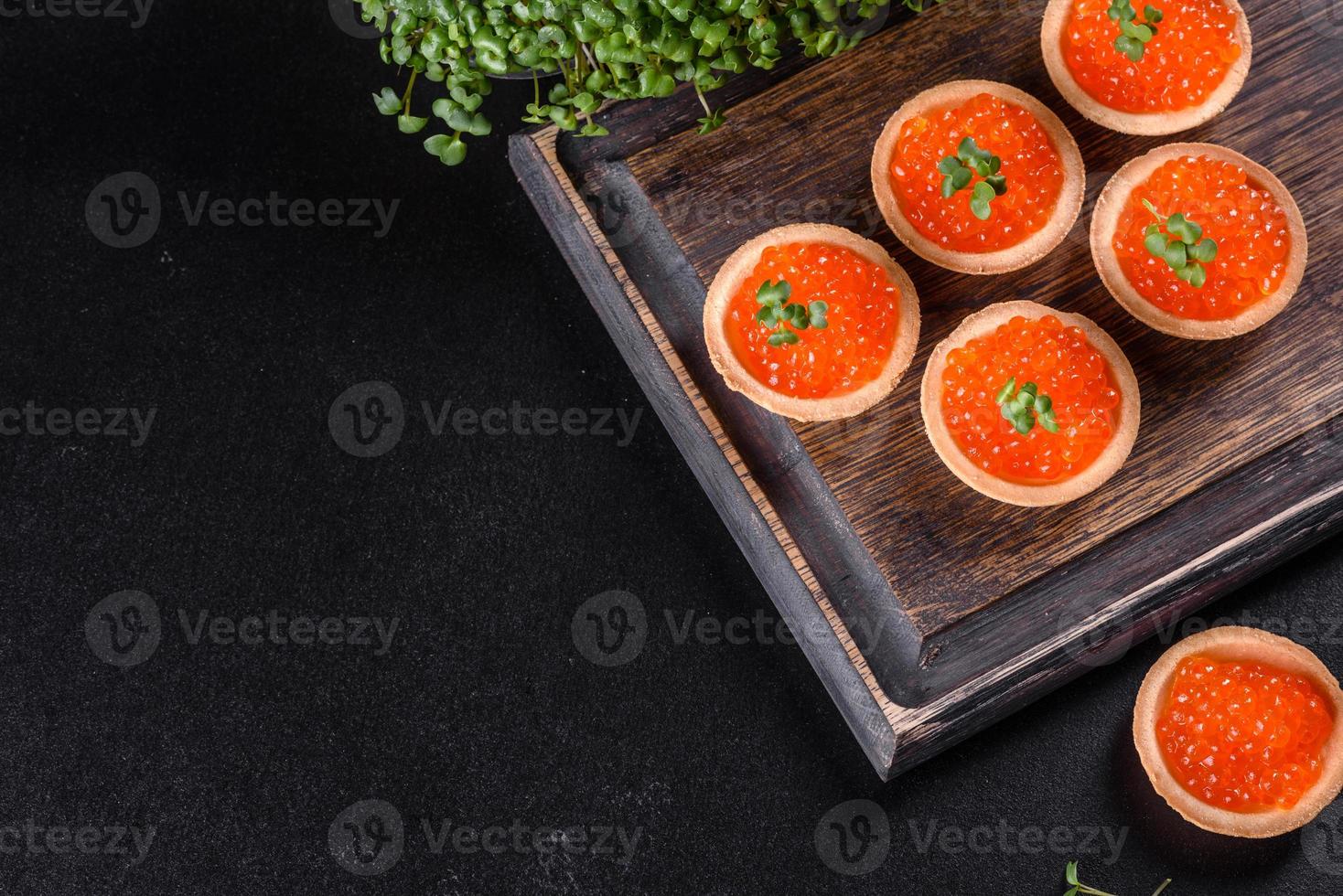 Caviar vermelho fresco delicioso em uma mesa de concreto escuro foto