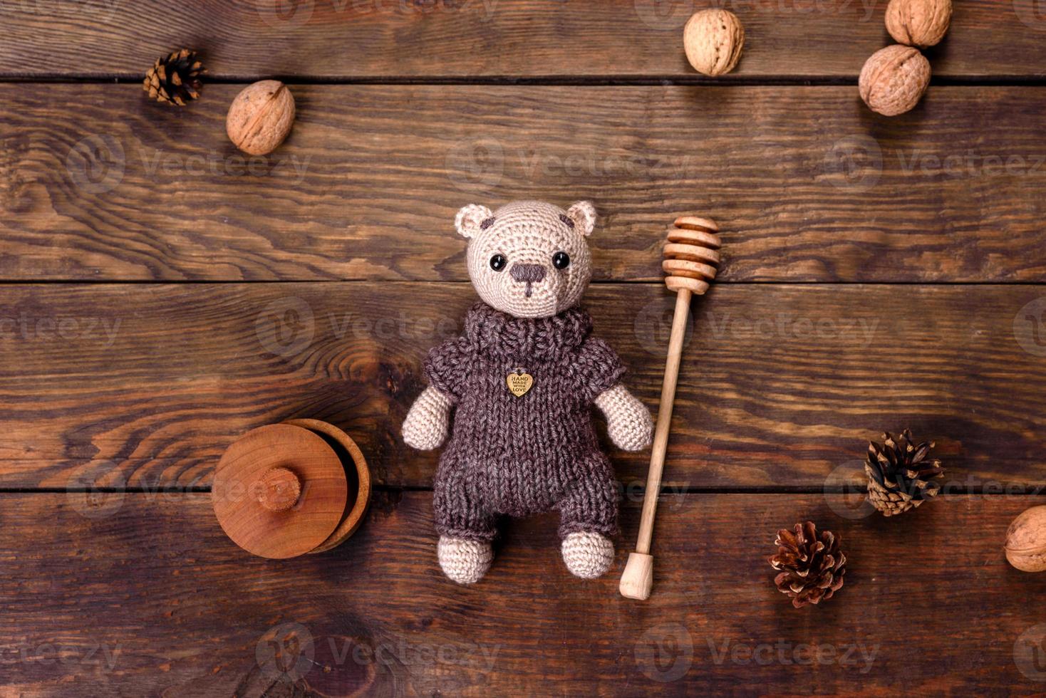 urso de brinquedo amarrado com fios de lã em um fundo escuro foto