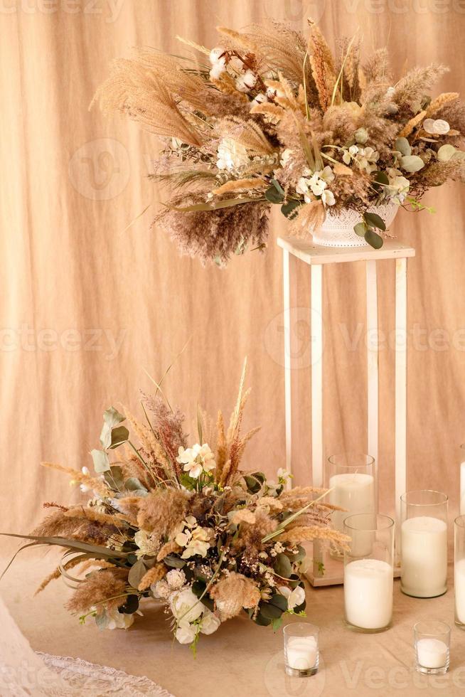 decorações de lindas flores secas em um vaso branco sobre um fundo de tecido bege foto