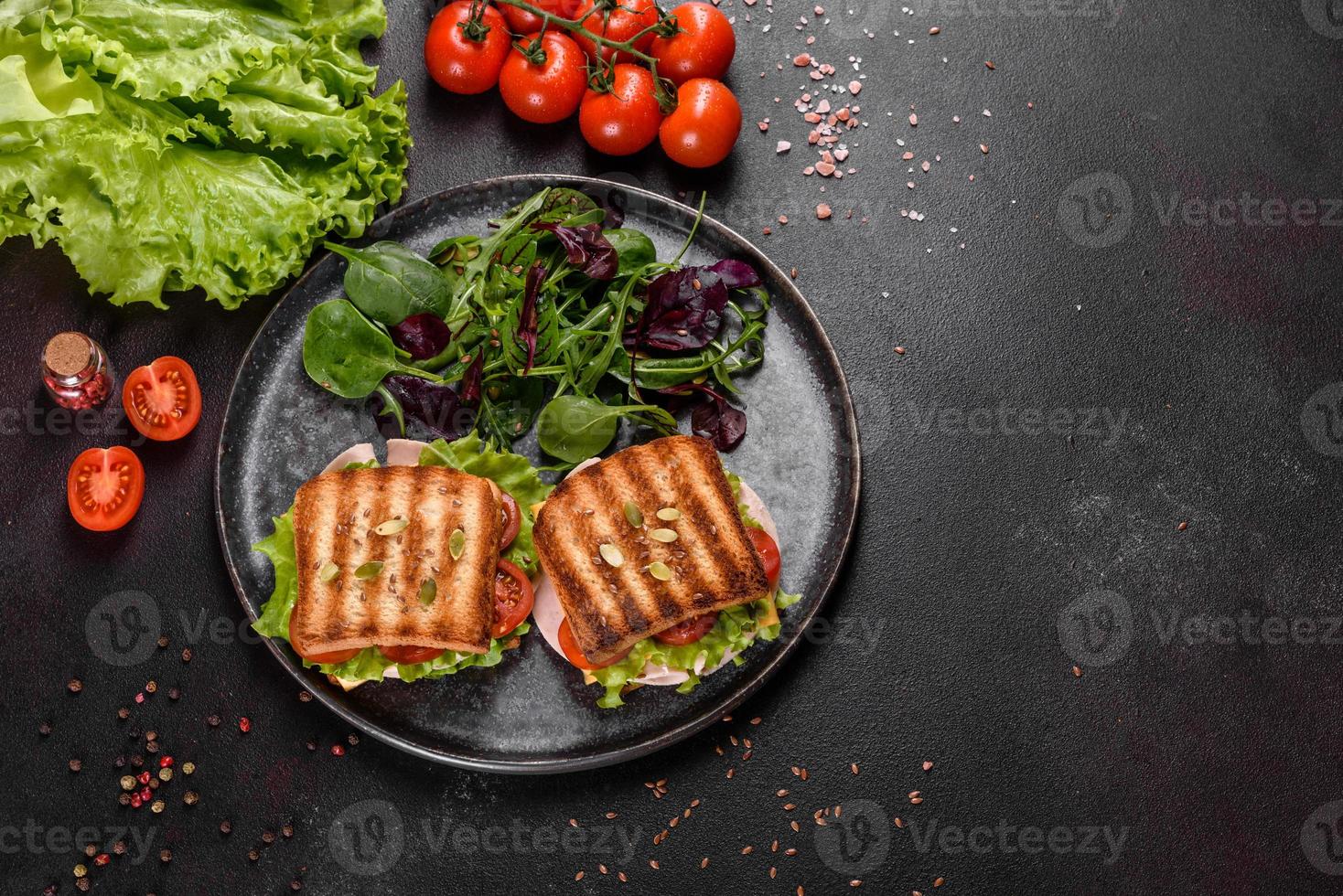 delicioso sanduíche com torradas crocantes, presunto, alface e tomate foto