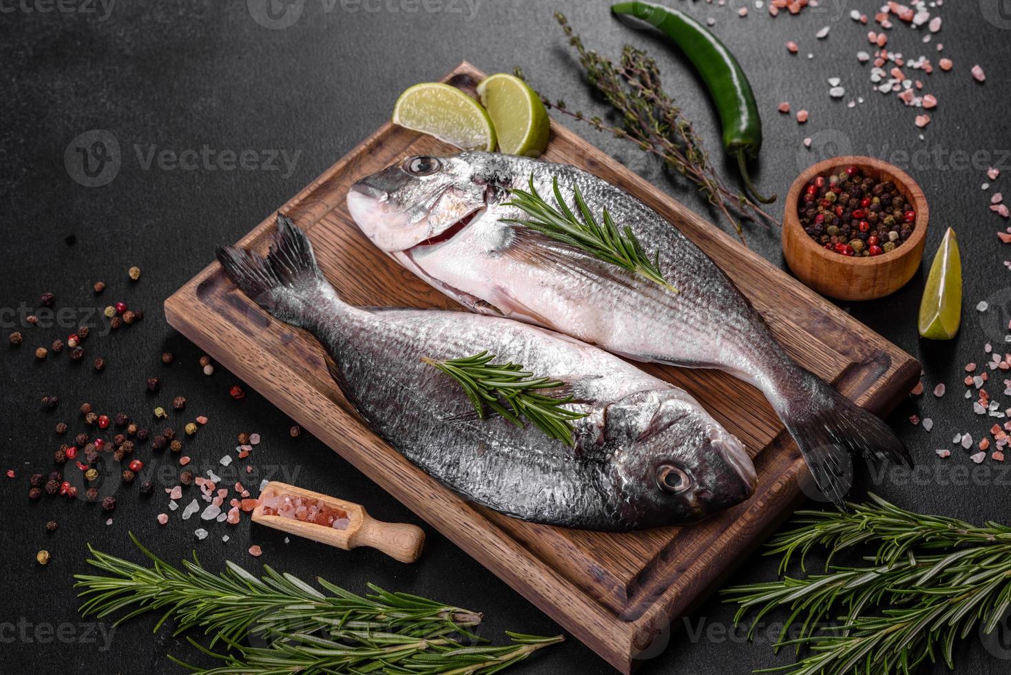 peixe dourado cru com especiarias, cozinhando na tábua. peixe fresco dourado foto