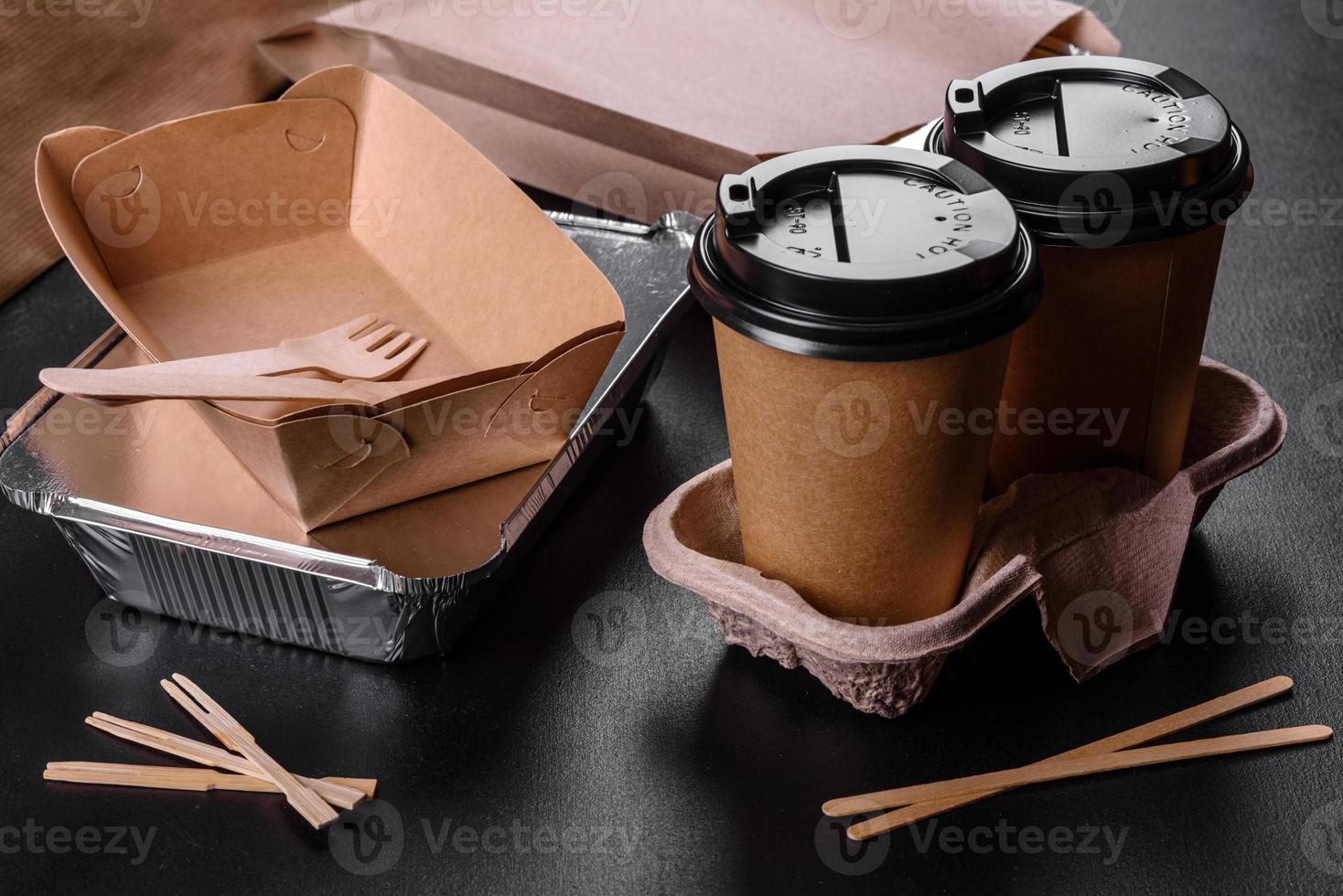 pratos descartáveis feitos de papelão marrom ecológico em um fundo escuro foto