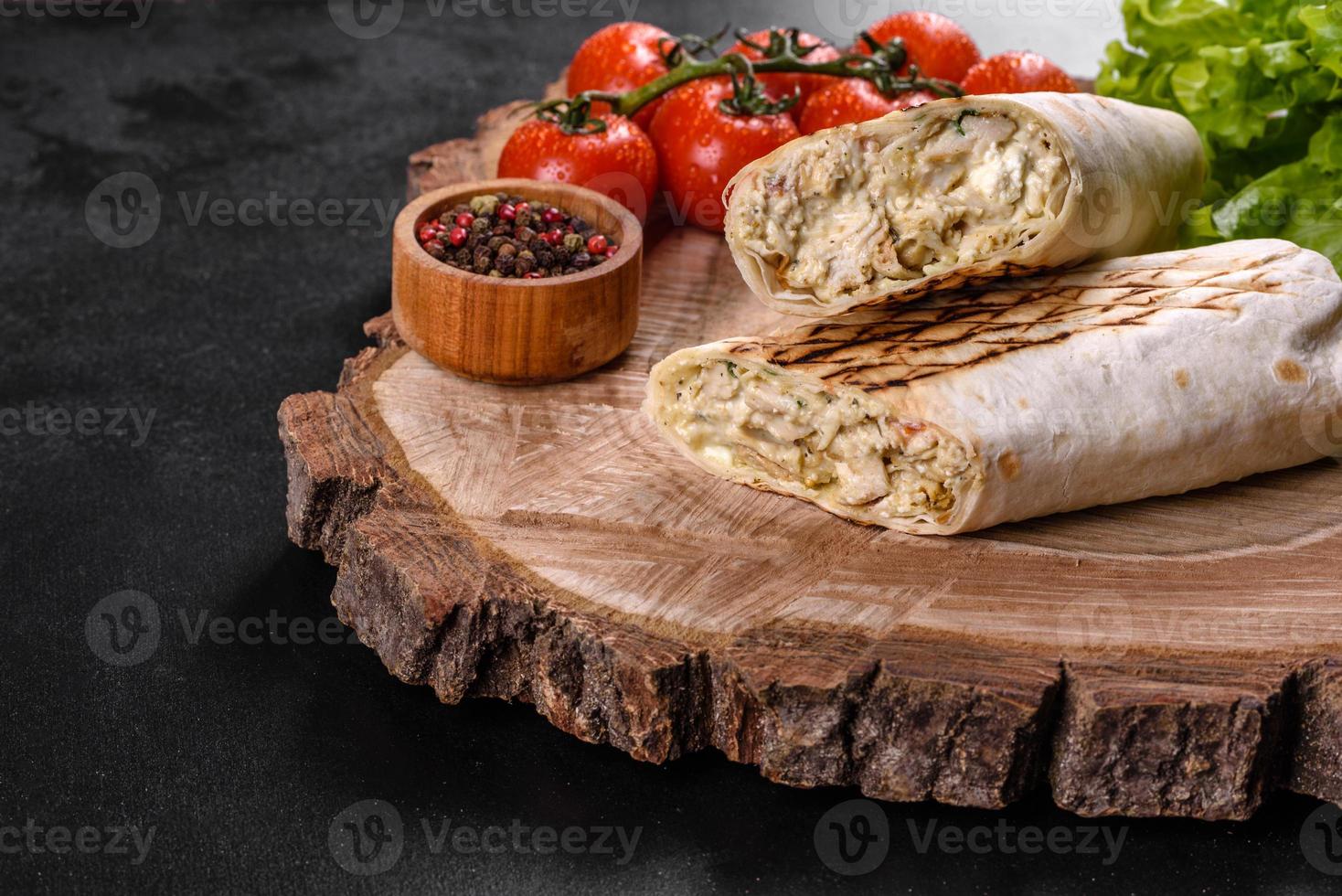 delicioso shawarma fresco com carne e vegetais em uma mesa de concreto escura foto