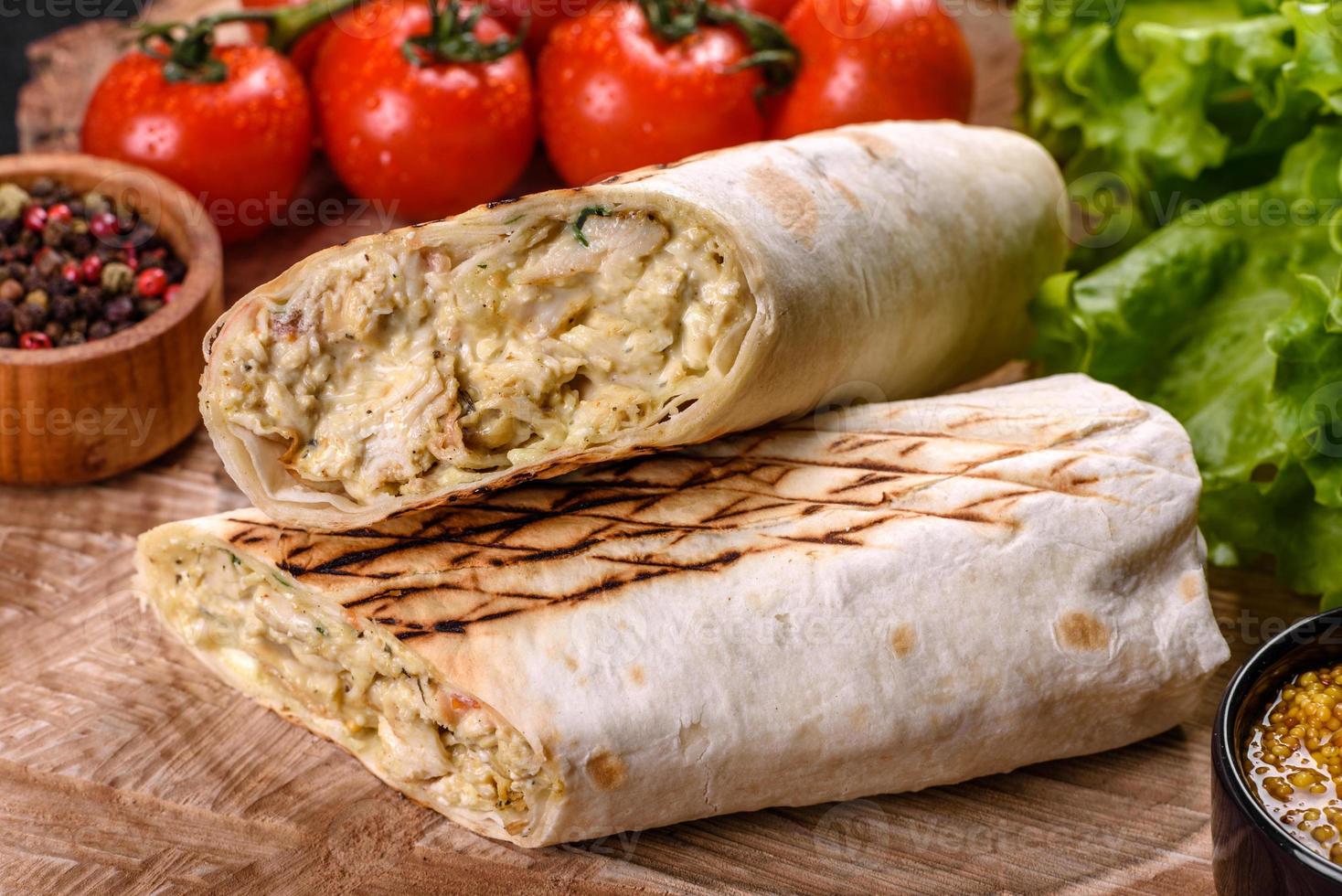 delicioso shawarma fresco com carne e vegetais em uma mesa de concreto escura foto