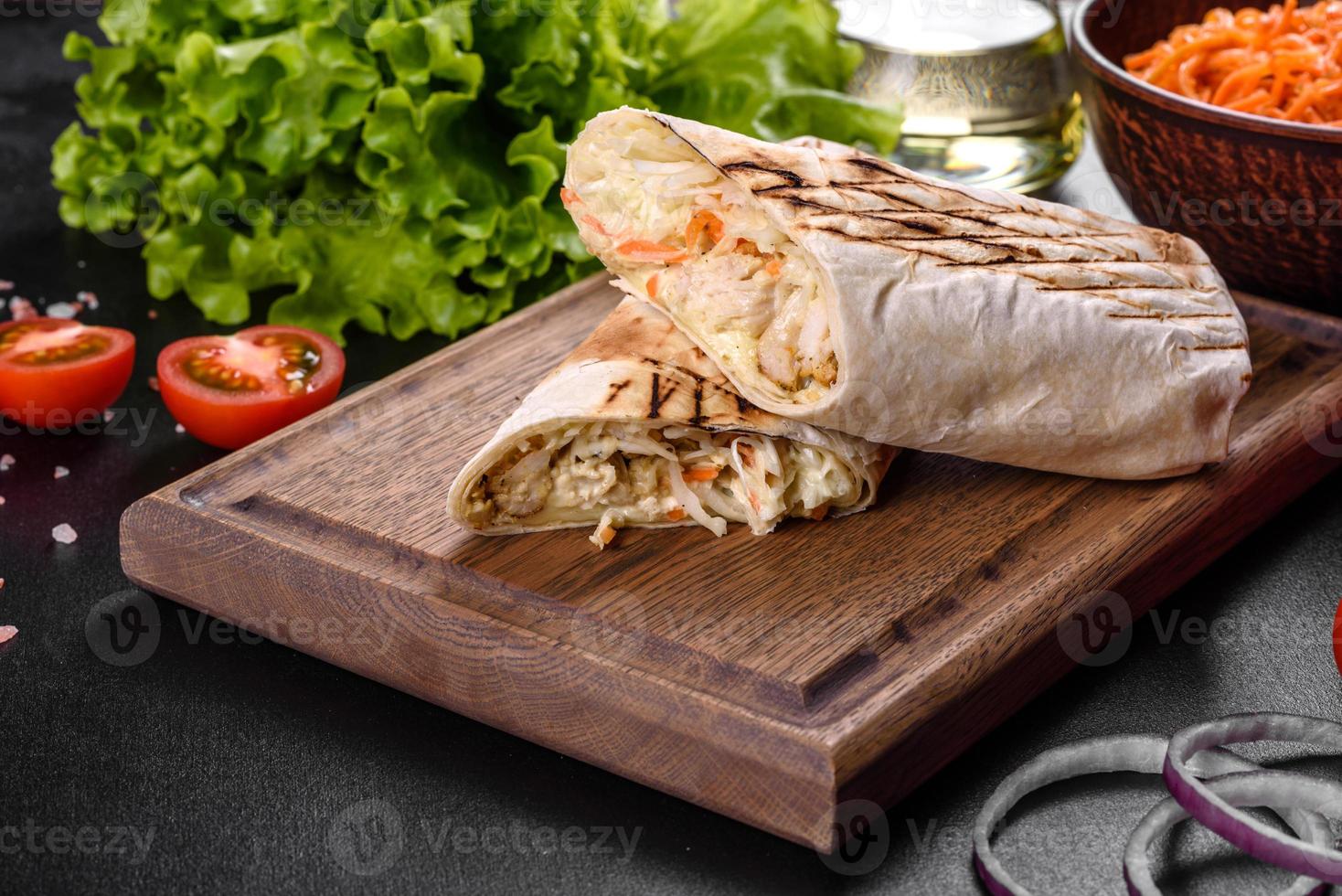 delicioso shawarma fresco com carne e vegetais em uma mesa de concreto escura foto