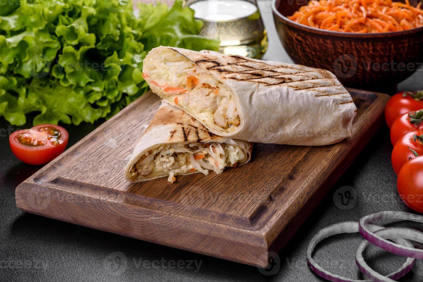 delicioso shawarma fresco com carne e vegetais em uma mesa de concreto escura foto