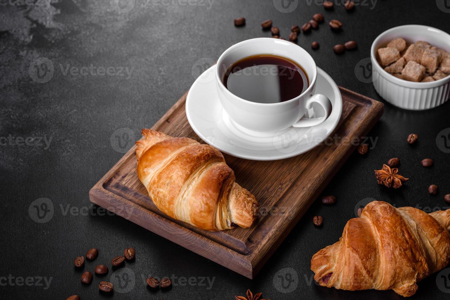 Crocante fresco e delicioso croissant francês com uma xícara de café perfumado foto