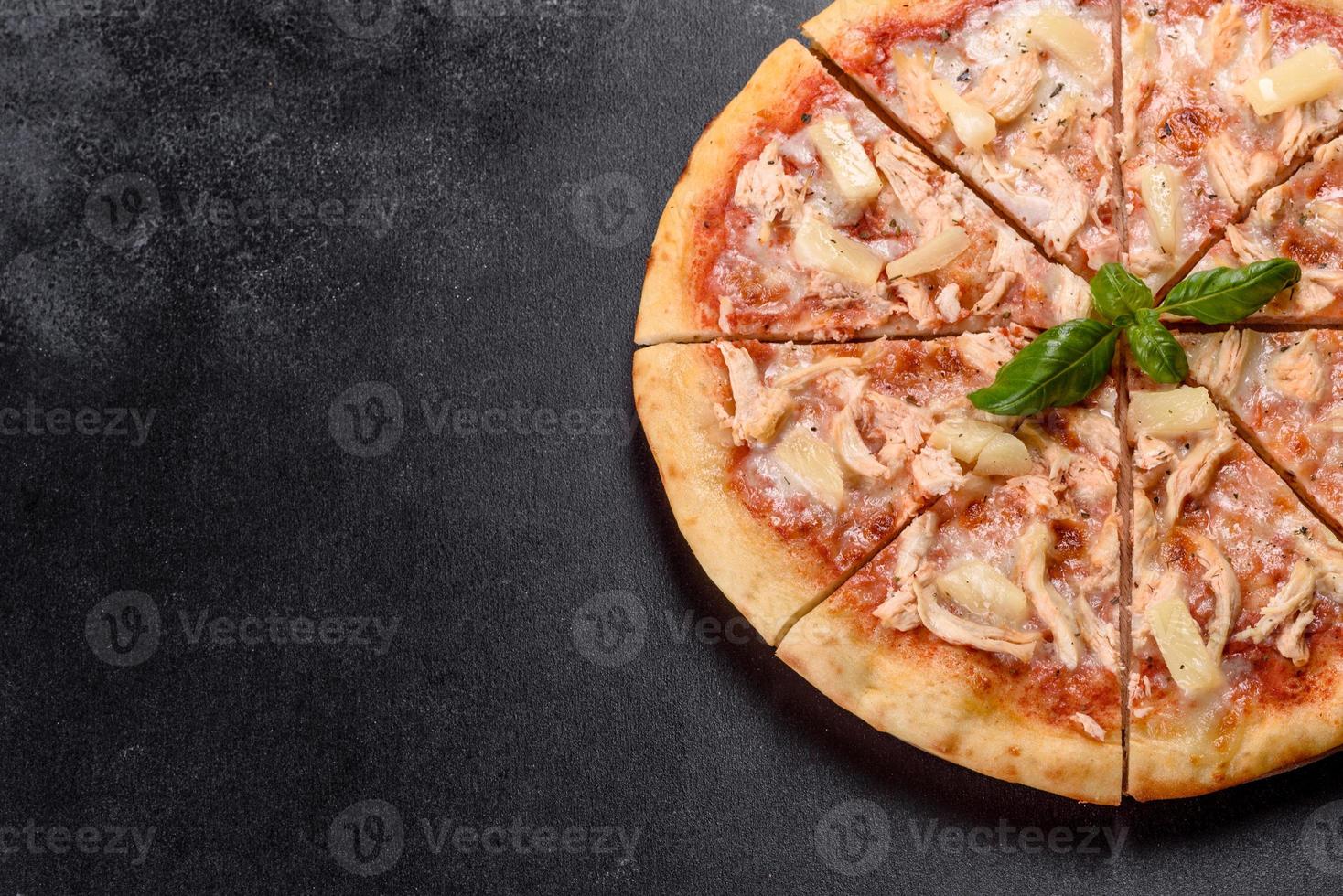 saborosa pizza fresca de forno com tomate, queijo e abacaxi em um fundo escuro de concreto foto