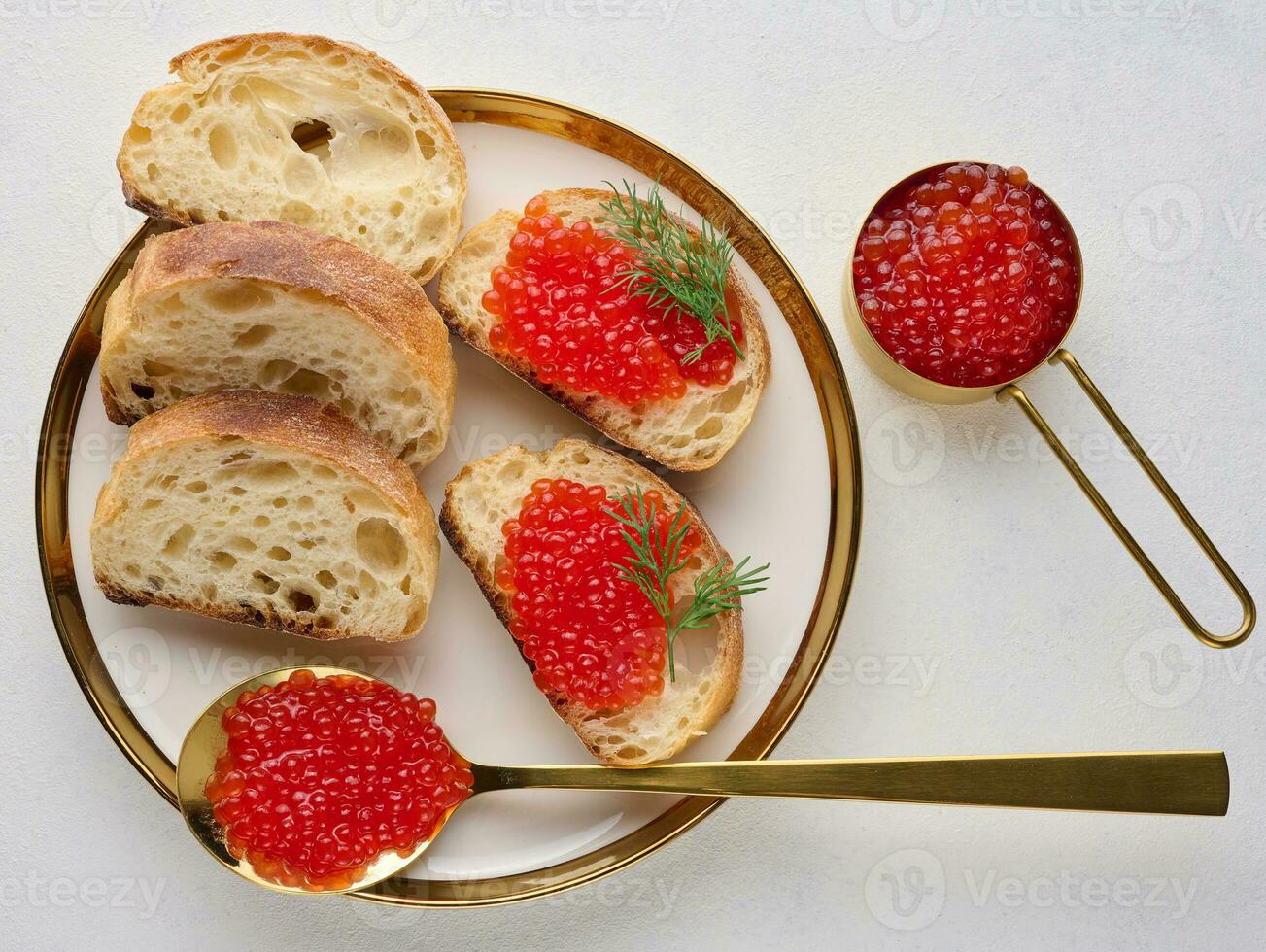 sanduíches com vermelho caviar e pão dentro uma volta prato em uma branco mesa, topo Visão foto