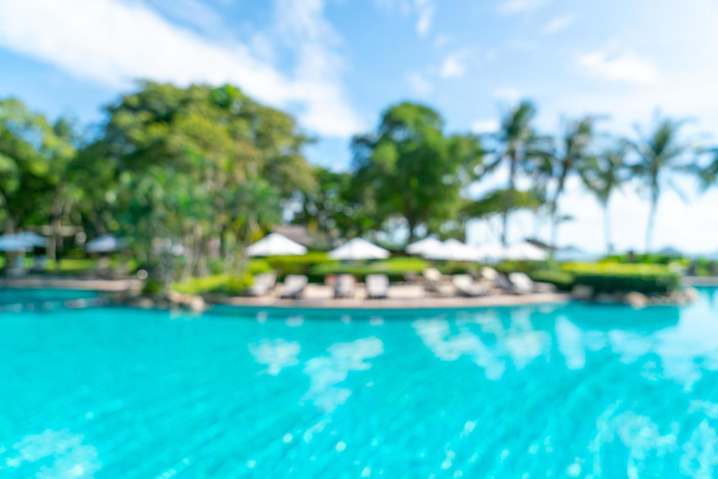 Resumo desfocar a piscina ao redor da piscina em um resort de hotel de luxo como plano de fundo - conceito de férias e férias foto