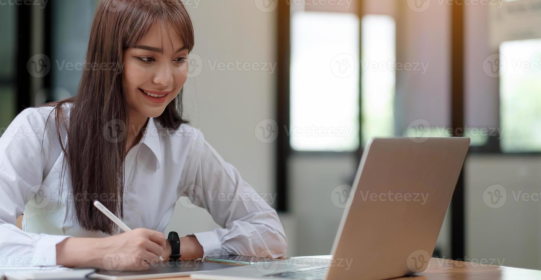 retrato de uma bela jovem estudando enquanto está sentada à mesa foto