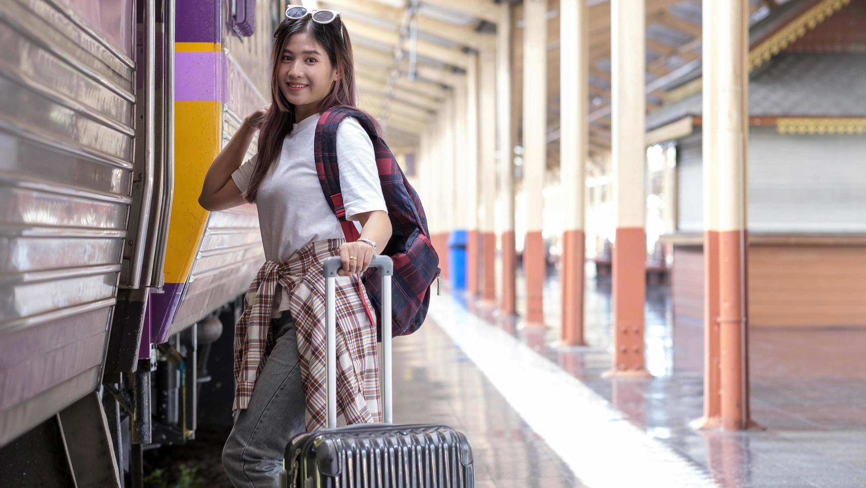 turista feminina feliz na estação ferroviária foto