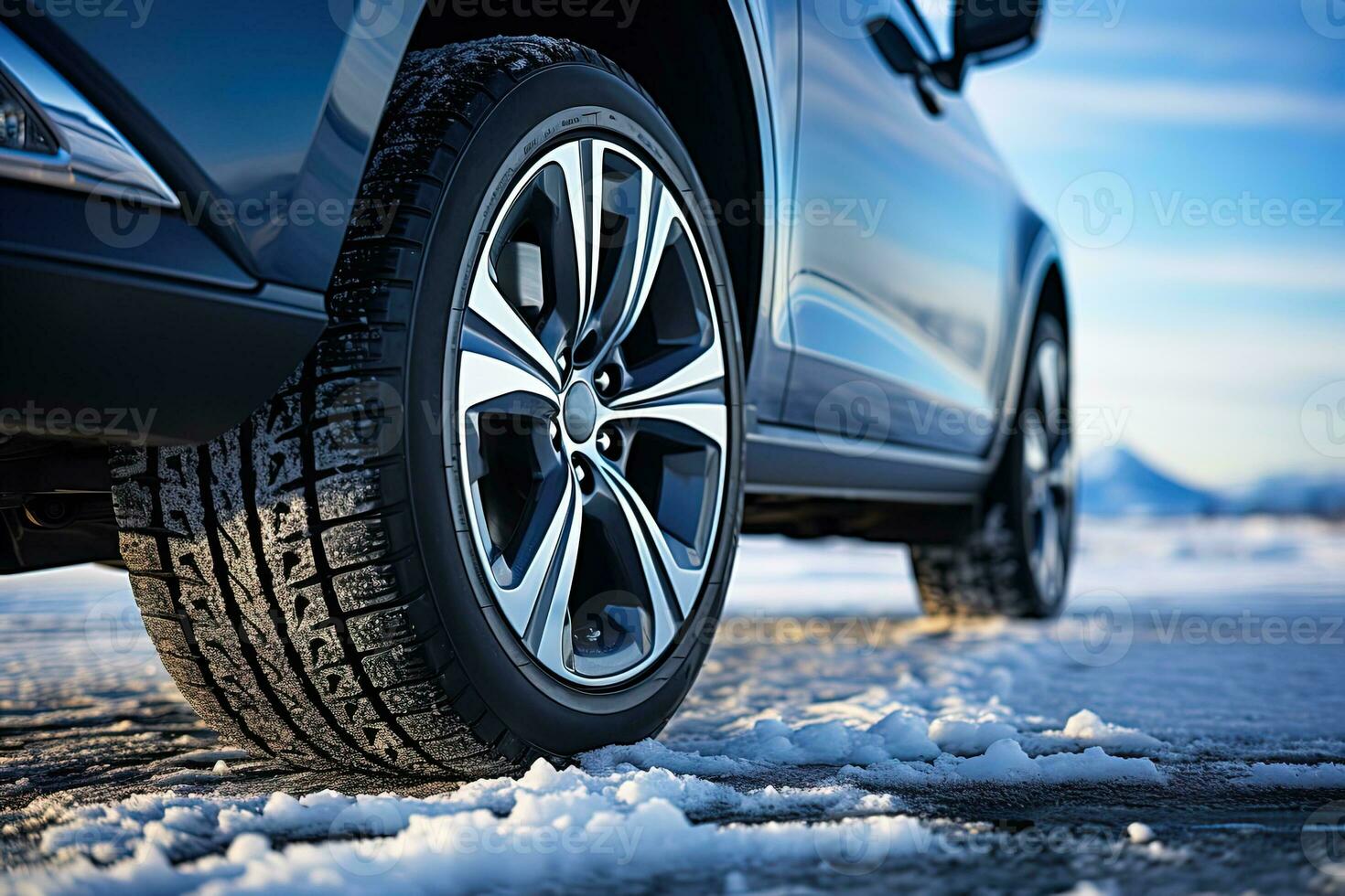 lado Visão do a azul carro com uma inverno pneus em uma Nevado estrada dentro ensolarado inverno dia foto