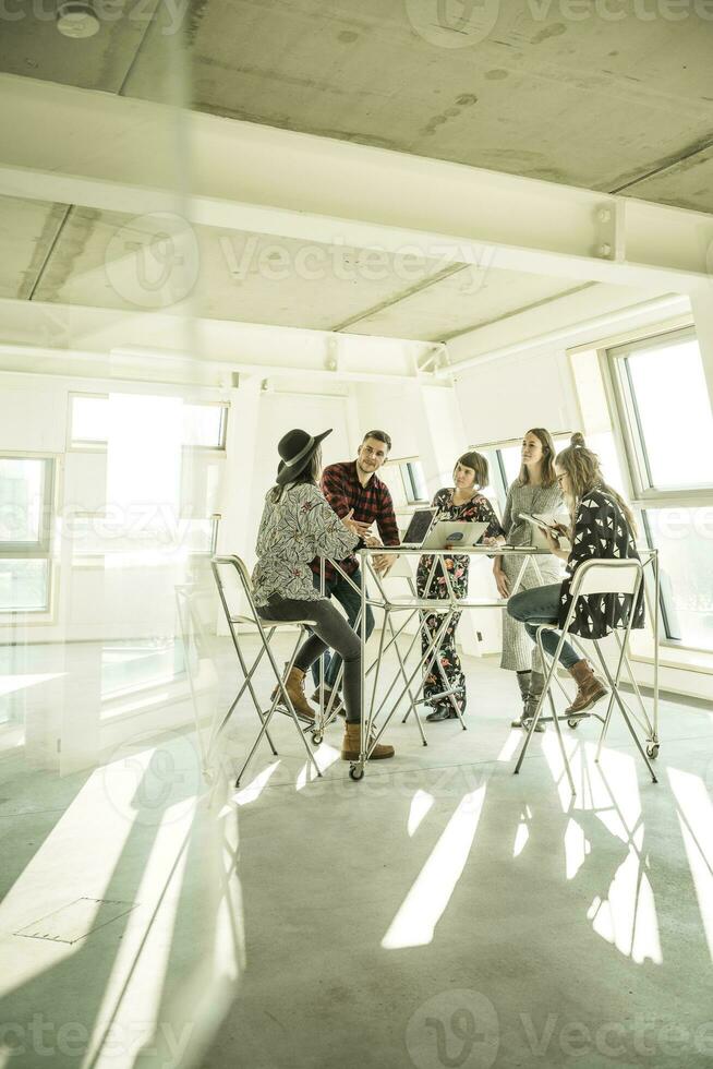 grupo do criativo profissionais tendo uma encontro dentro uma brilhante escritório, discutindo Novo soluções foto