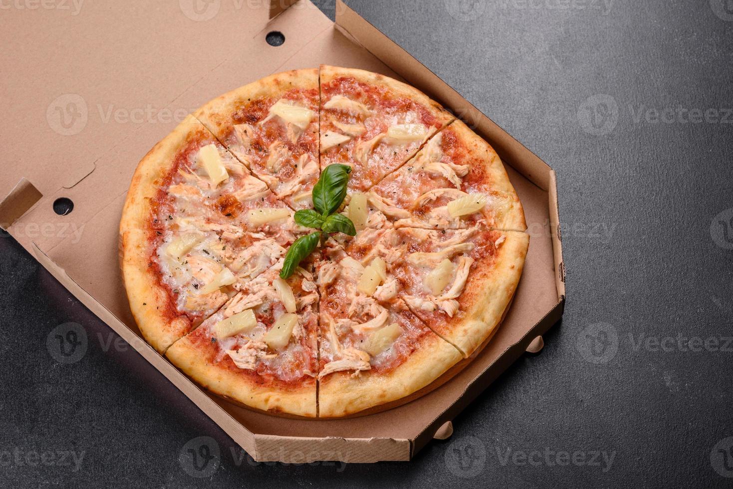 saborosa pizza fresca de forno com tomate, queijo e abacaxi em um fundo escuro de concreto foto