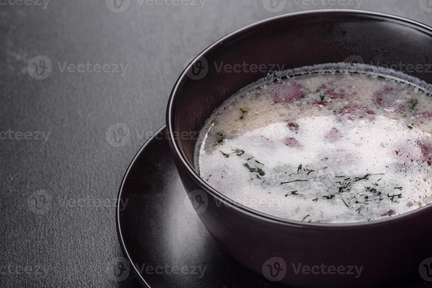 sopa de queijo com salsichas fritas e ervas. saborosa sopa de cream cheese foto