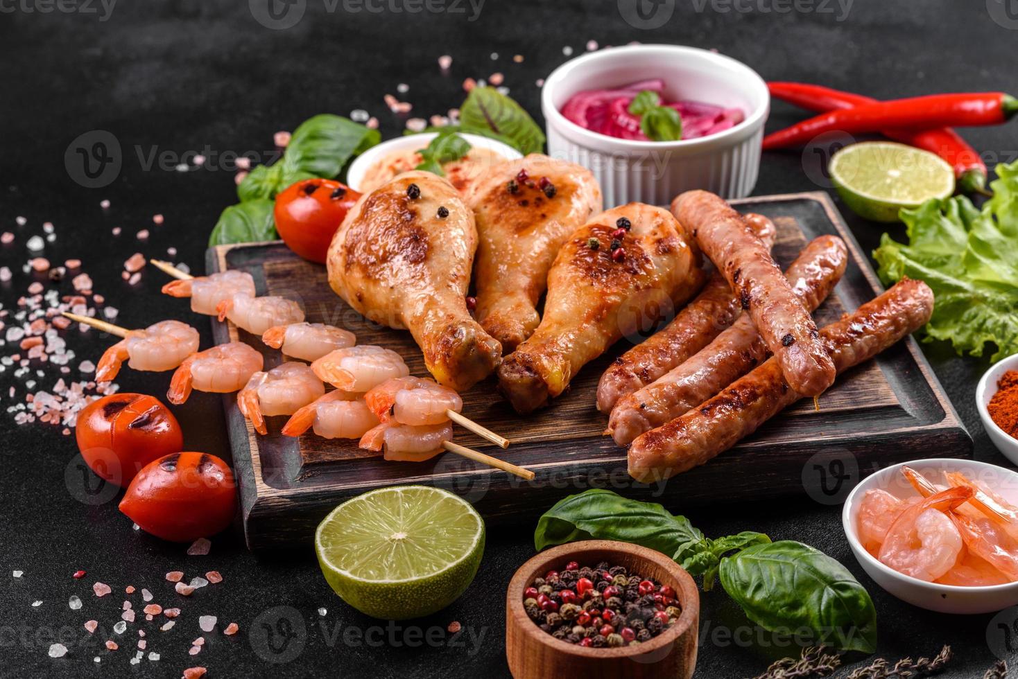 composição de salsichas, frango, porco e camarão preparado na grelha, bem como vegetais preparados na grelha com especiarias e ervas foto