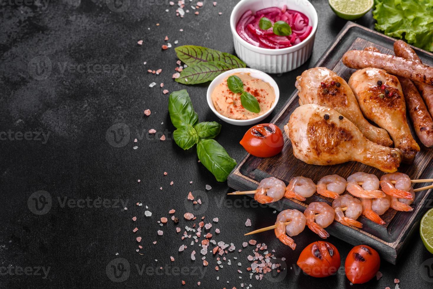 composição de salsichas, frango, porco e camarão preparado na grelha, bem como vegetais preparados na grelha com especiarias e ervas foto