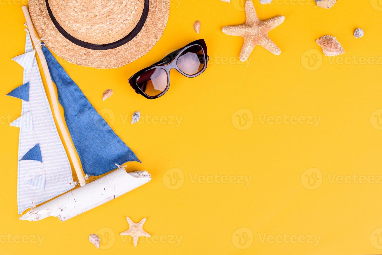 óculos e chapéu com conchas e estrelas do mar em um fundo colorido foto