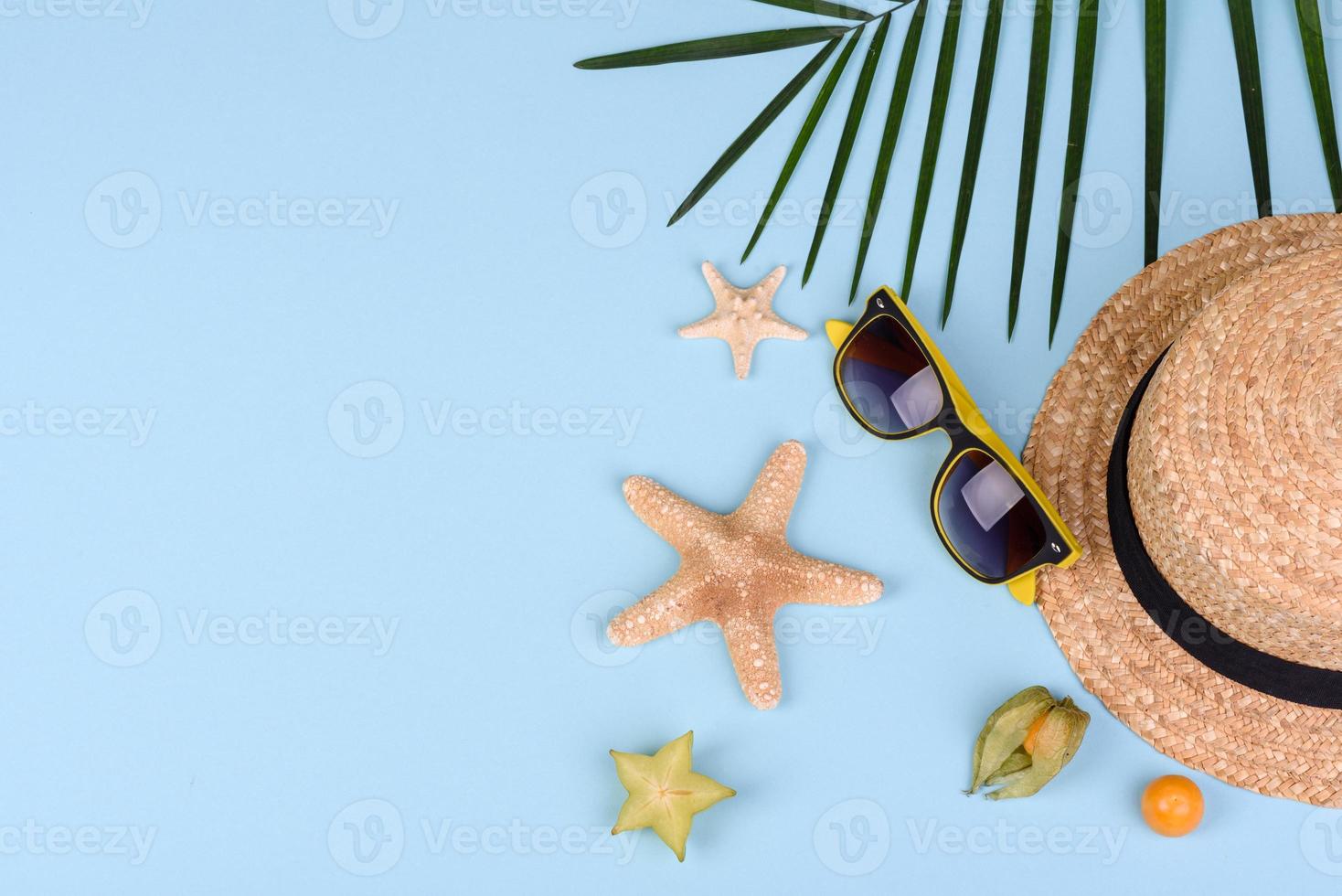 carambola de frutas, acessórios de praia e folhagem de planta tropical em papel colorido foto