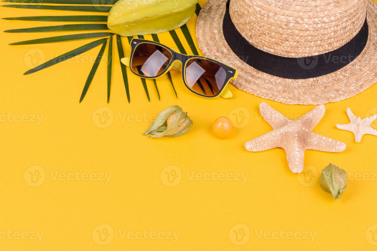 carambola de frutas, acessórios de praia e folhagem de planta tropical em papel colorido foto