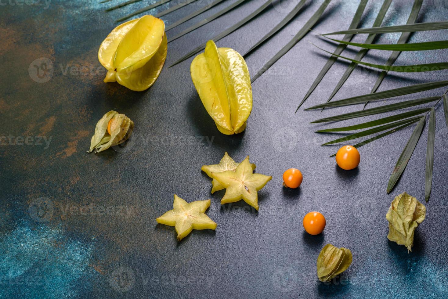 carambola de frutas, acessórios de praia e folhagem de planta tropical em papel colorido foto