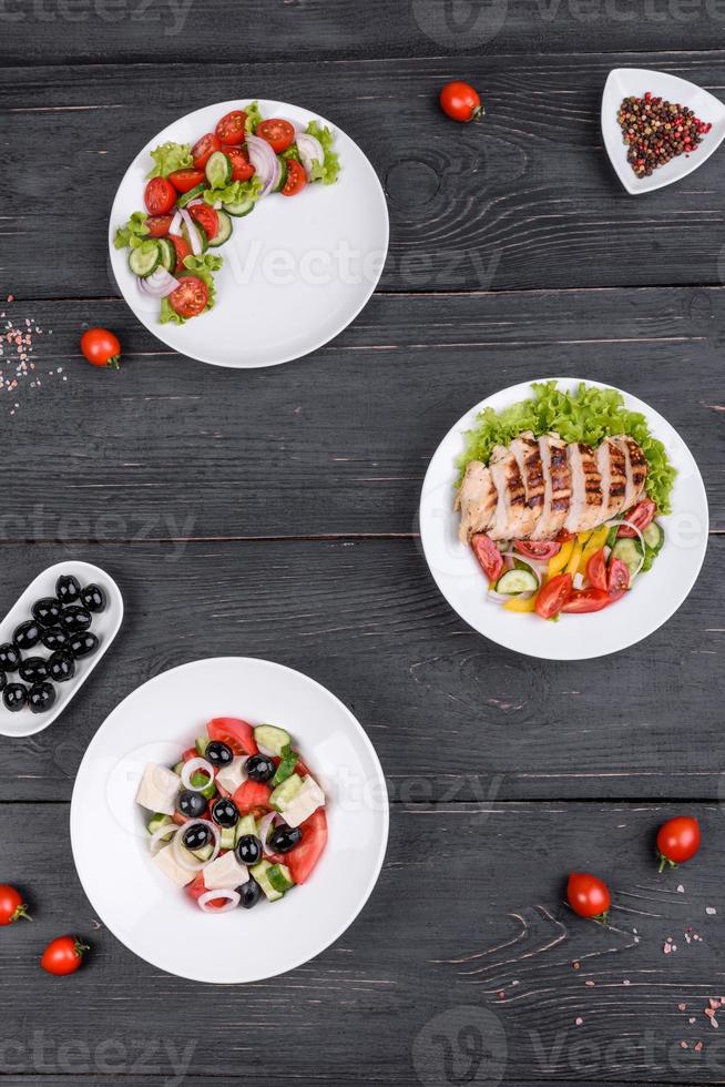 três deliciosas saladas frescas com frango, tomate, pepino, cebola e verduras com azeite de oliva foto