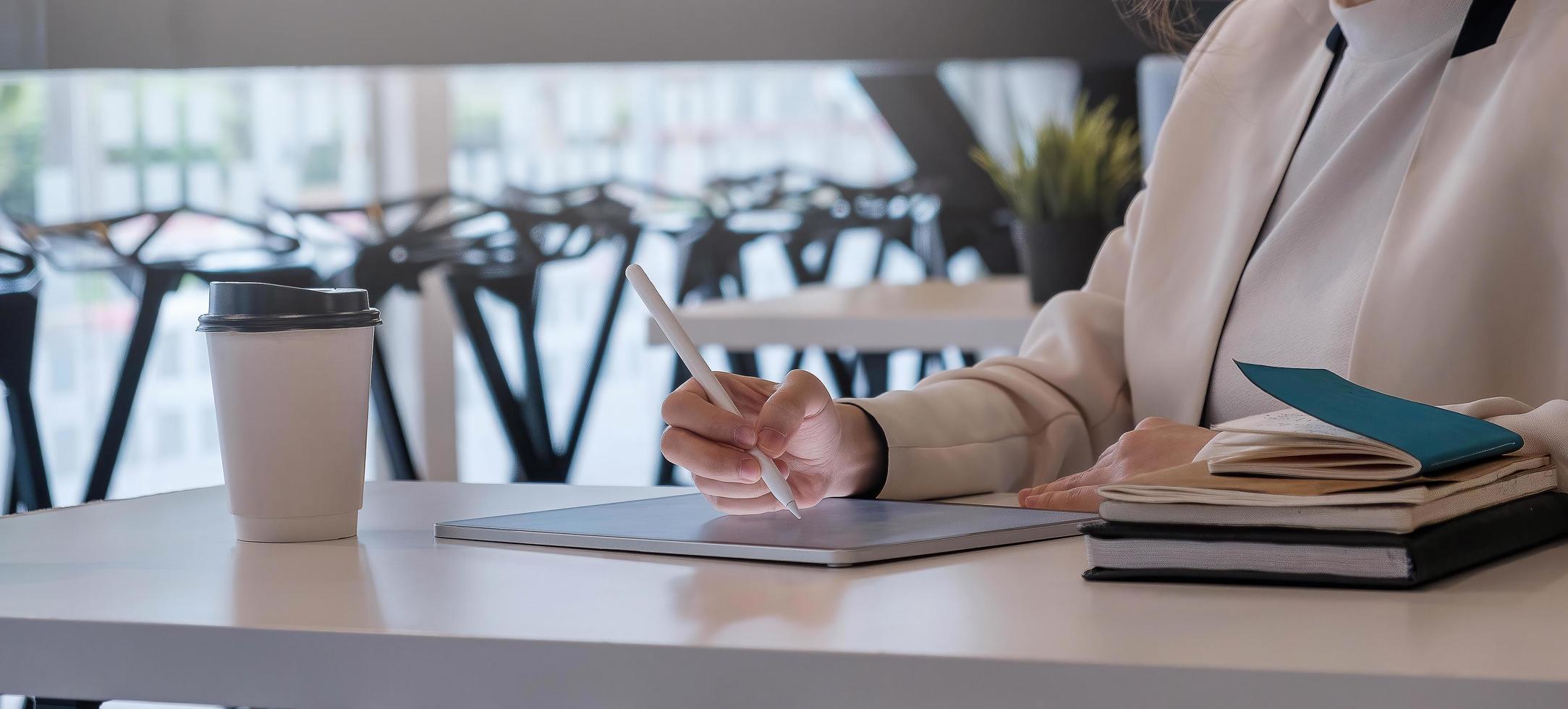 mulher segurando um tablet digital com tela em branco e caneta stylus foto