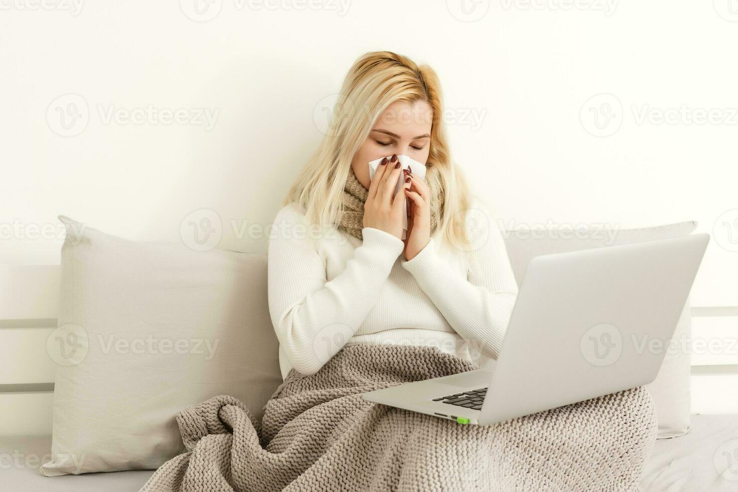 atraente e chocado mulher com cinzento cachecol segurando computador portátil foto