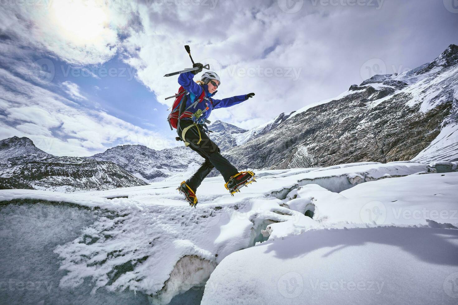 fêmea alpinista pulando sobre fenda, geleira vendedor bruto, Tirol, Áustria foto