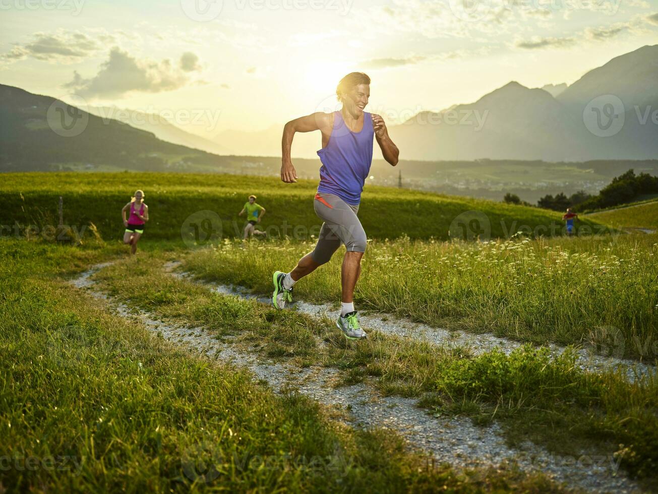 atletas corrida em campo caminho às pôr do sol foto