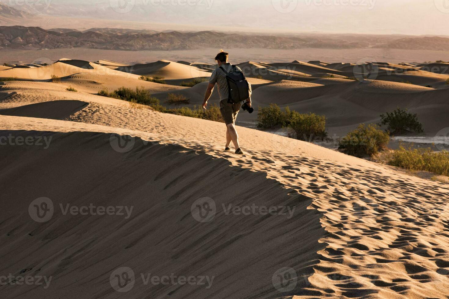 EUA, Califórnia, morte vale, morte vale nacional parque, algaroba plano areia dunas, homem caminhando em duna foto