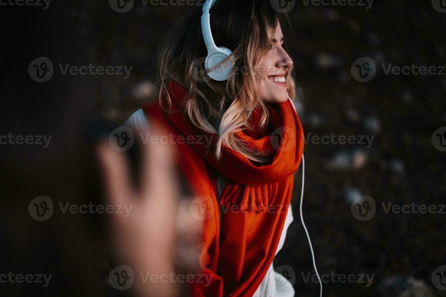 lindo mulher ouvindo para música dentro floresta durante pôr do sol foto