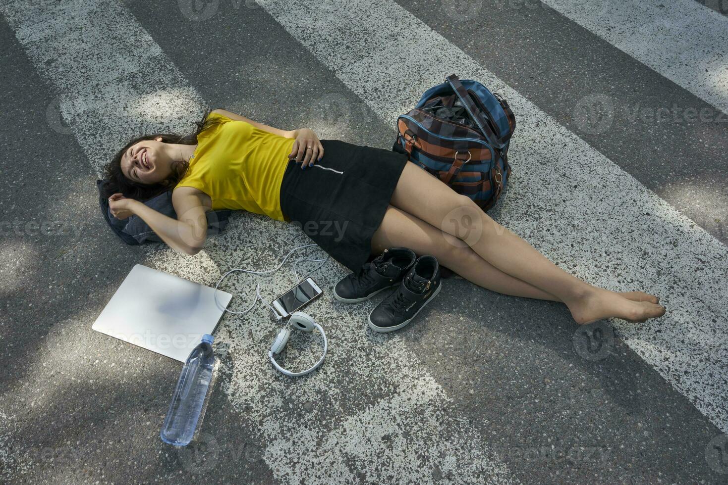 jovem mulher deitado em zebra cruzando levando uma pausa foto