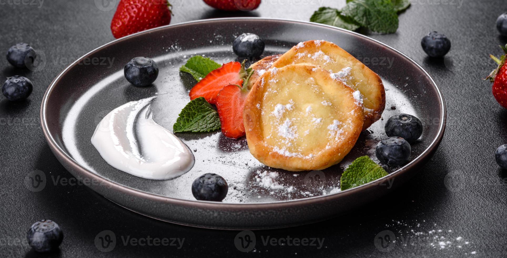 saborosas panquecas assadas com frutas e hortelã com açúcar de confeiteiro e cobertura em um prato cinza foto