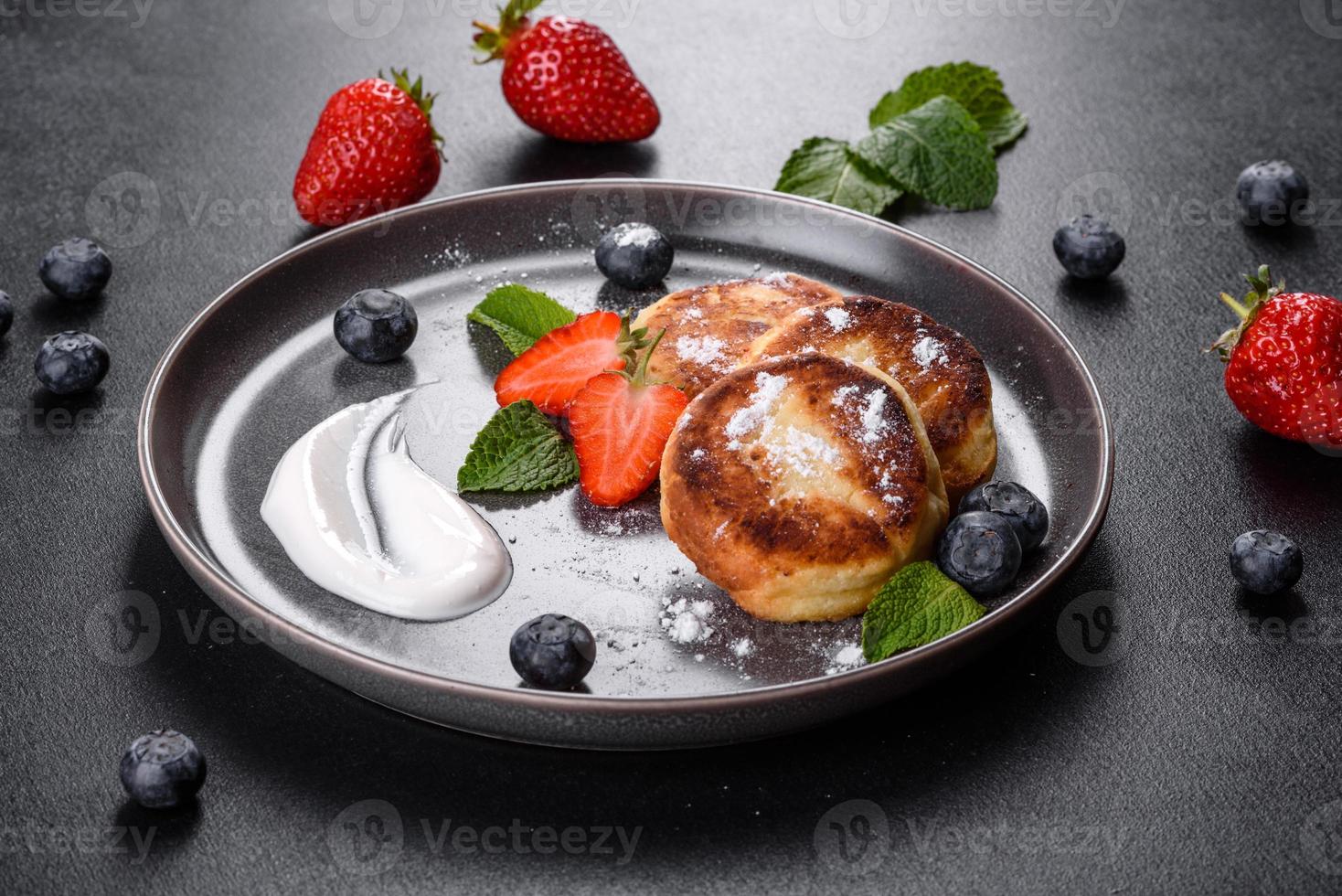 saborosas panquecas assadas com frutas e hortelã com açúcar de confeiteiro e cobertura em um prato cinza foto