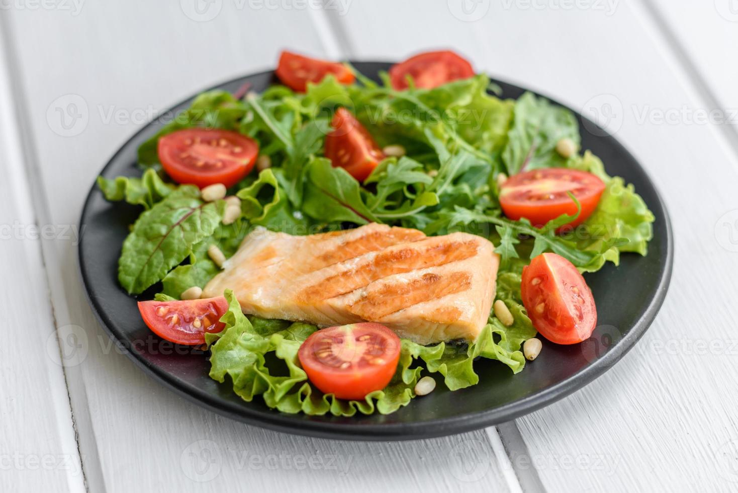 deliciosa salada fresca com peixe, tomate e folhas de alface foto